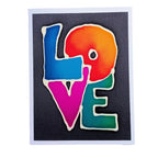 A hand painted pure silk original art greeting card featuring the word 'LOVE' in large, colorful gradient letters outlined in white, set against a dark charcoal background with a white border.