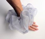 Load image into Gallery viewer, A sheer, ruffled wrist pure silk ORGANZA Oversized scrunchie cuff in a pale lavender-gray color, worn on a person's wrist with their hand resting 
