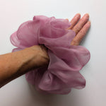 Load image into Gallery viewer, A dusty pink sheer PURE SILK ORGANZA hair scrunchie being worn on a person's hand, shown against a plain white background.

