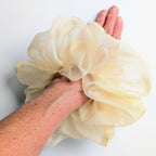 pure silk organza oversized jumbo hair scrunchie  lightweight cream-colored worn on a person's wrist, 