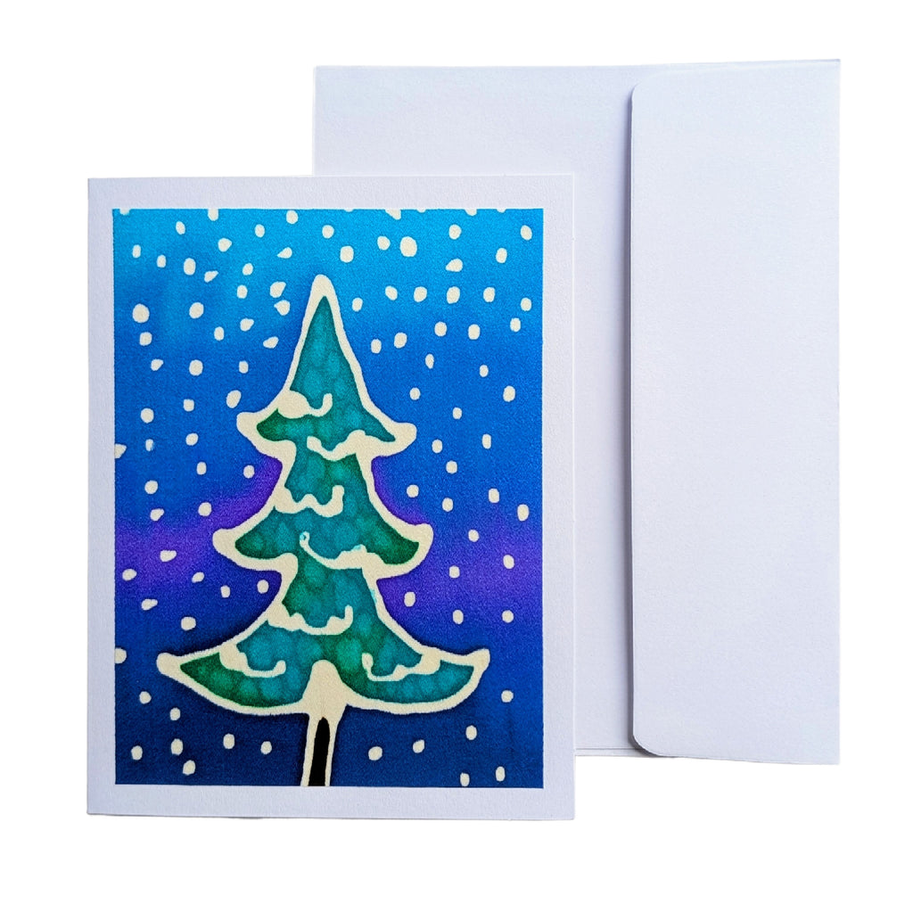 A hand painted pure silk original art Christmas greeting card with a hand-painted green and blue tree design, shown with its white envelope behind it 