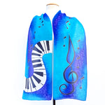 Load image into Gallery viewer, painted silk piano scarf with treble clef and music notes in blue
