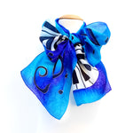 Load image into Gallery viewer, hand painted silk blue piano scarf tied in a bow blue turquoise purple colors
